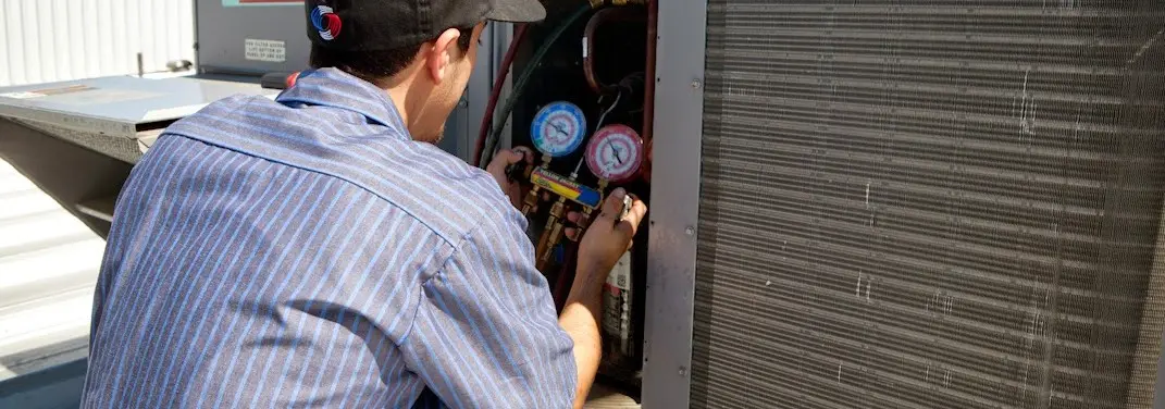 HVAC technician servicing a condenser unit in Van Wert